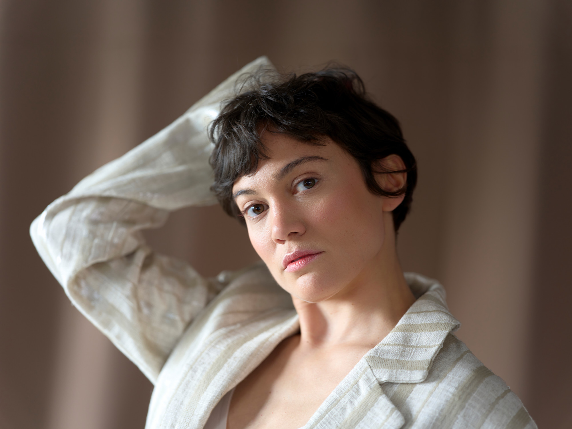 Schauspielerin Milena Straube im gestreiften Leinensakko, den Arm &uuml;ber den Kopf gelegt, Schauspielerportr&auml;t von Martina Thalhofer, Berlin