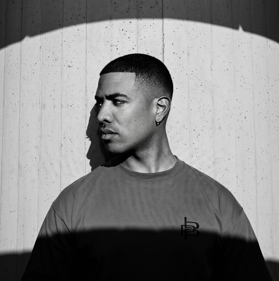 Modell im Profil vor einer Betonwand im harten Sonnenlicht, Schwarzweiß, Fashion-Strecke Piece by Piece