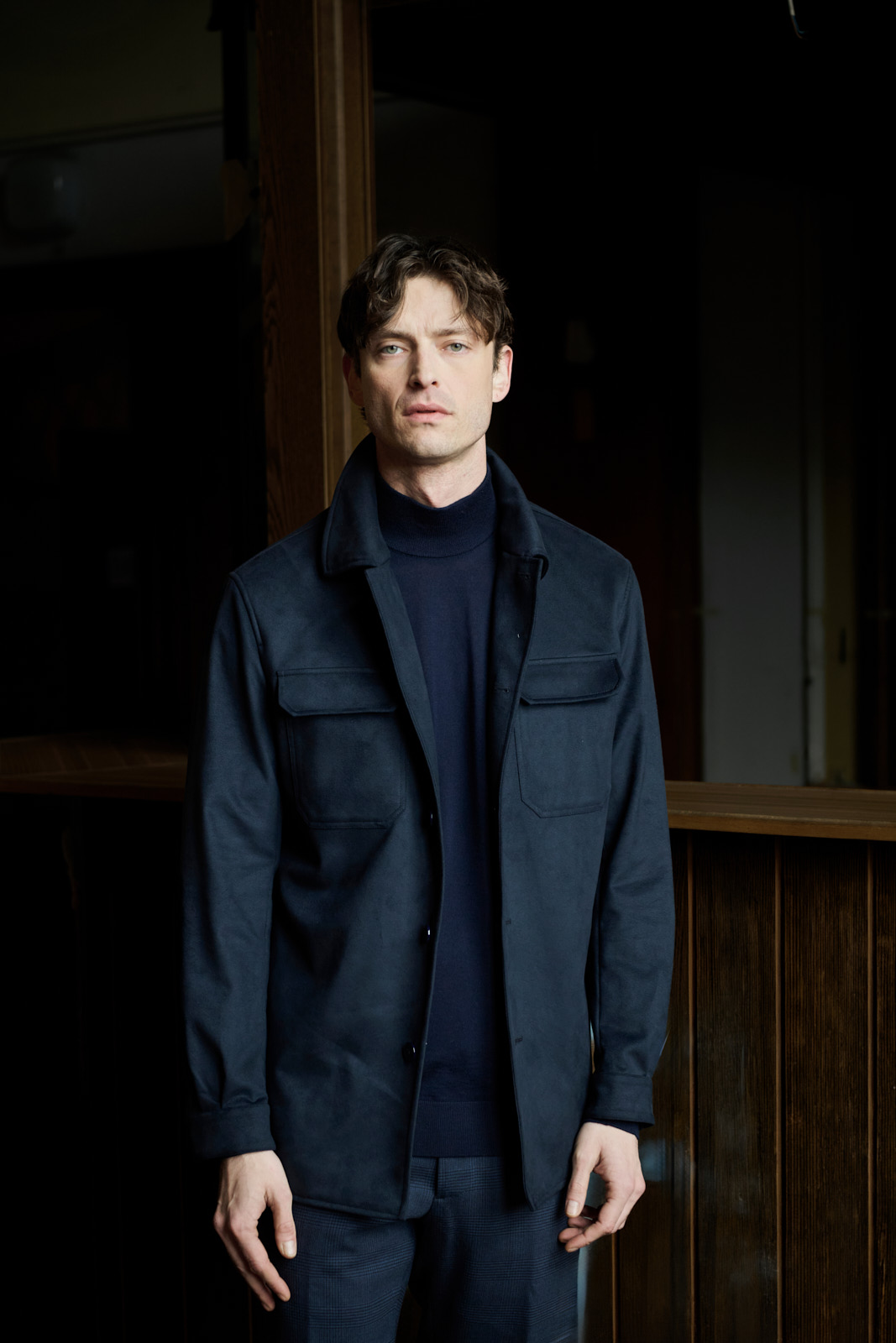 Fashion-Editorial für Azzur, Modell im dunkelblauen Overshirt im Türrahmen