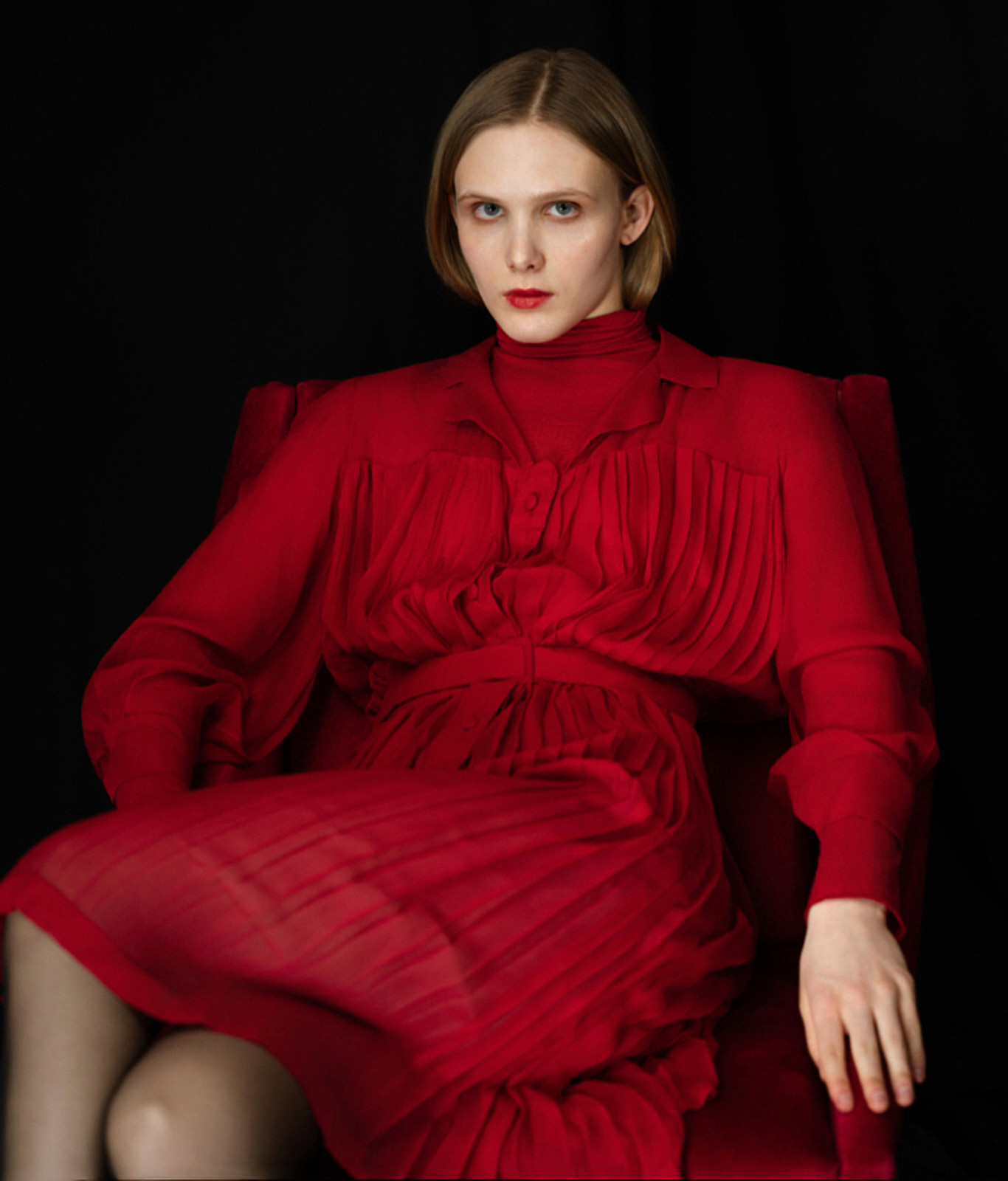 Viktoria Yerchyk in rotem Kleid vor dunklem Grund, Ganzkörperaufnahme, Fashion-Strecke